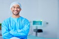 Portrait, surgeon and Asian man with arms crossed in hospital, healthcare and wellness. Face, happy doctor and medical