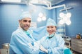 Portrait of surgeon and nurse standing with arms crossed in operation room Royalty Free Stock Photo