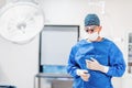 Portrait of surgeon in operating room. Cosmetic plastic surgeon wearing scrubs, goggles and gloves getting ready for surgery Royalty Free Stock Photo