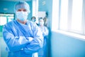 Portrait of surgeon standing with arms crossed in corridor Royalty Free Stock Photo