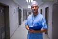 Portrait of surgeon standing with clipboard in corridor Royalty Free Stock Photo