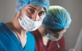 Portrait of surgeons at work, operating in uniform, looking at camera.