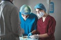 Portrait of surgeons at work, operating in uniform, looking at camera.