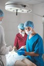 Portrait of surgeons at work, operating in uniform, looking at camera.