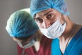 Portrait of surgeons at work, operating in uniform, looking at camera.