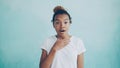 Portrait of surprised African American lady raising her eyebrows and covering her opened mouth with hand expressing