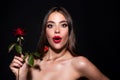 Portrait of surprised attractive woman with red rose. Royalty Free Stock Photo