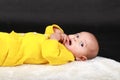 Portrait of surprised baby boy lying on back on white fur Royalty Free Stock Photo