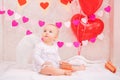 Portrait of a surprised baby with white feather wings, with gifts in boxes, symbols of Valentine`s Day Royalty Free Stock Photo