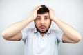 Portrait of a surprised bearded man with eyes and mouth wide open, holding his head with his hands, on a white Royalty Free Stock Photo