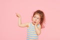 Portrait of surprised cute little toddler girl child over pink background. Looking at camera. Royalty Free Stock Photo