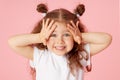 Portrait of surprised cute little toddler girl child over pink background. Looking at camera. Royalty Free Stock Photo