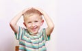 Portrait of surprised emotional blond boy child kid at the table Royalty Free Stock Photo