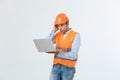 Portrait of a surprised engineer holding his laptop over gray background. Royalty Free Stock Photo