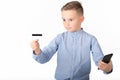 Portrait of a surprised european boy holding mobile phone and credit card. Young man looking at credit card Royalty Free Stock Photo