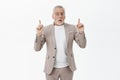 Portrait of surprised excited and thrilled charming funny mature male with white hair and beard in glasses and elegant