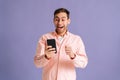 Portrait of surprised excited young man screaming during using mobile cell phone just found out great big win news Royalty Free Stock Photo