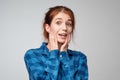 Portrait of surprised ginger female dressed casually in blue t-shirt, having bated breath.