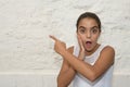 Portrait of a surprised girl pointing her finger at the copy space Royalty Free Stock Photo