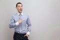 Portrait of surprised handsome bristle businessman in classic blue shirt standing and pointing at side copyspace and looking at Royalty Free Stock Photo