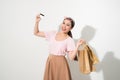 Portrait of a surprised happy girl holding shopping bags and showing credit card while looking at camera isolated over white back Royalty Free Stock Photo