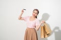 Portrait of a surprised happy girl holding shopping bags and showing credit card while looking at camera  over white Royalty Free Stock Photo