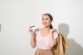 Portrait of a surprised happy girl holding shopping bags and showing credit card while looking at camera isolated over white Royalty Free Stock Photo
