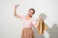 Portrait of a surprised happy girl holding shopping bags and showing credit card while looking at camera isolated over white Royalty Free Stock Photo