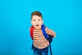 Portrait of surprised happy three year old preschooler with a backpack on blue background.For the first time to school. Royalty Free Stock Photo
