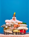 Portrait of surprised little princess in yellow crown sitting on big pile of pillows and drinking fresh, healthy juice. Royalty Free Stock Photo