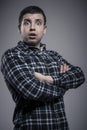 Portrait of surprised man in checked shirt with arms crossed Royalty Free Stock Photo