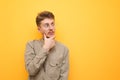 Portrait of surprised nerd student in glasses and shirt on yellow background, looking away at copy space with emotional face. Royalty Free Stock Photo