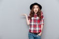 Portrait of a surprised shocked young woman in plaid shirt