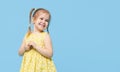 Portrait of surprised smiling cute little toddler girl. child standing isolated over blue background. Royalty Free Stock Photo