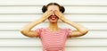 Portrait of surprised smiling young woman covering her eyes wearing a striped t-shirt with cool hairstyle on white Royalty Free Stock Photo