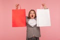 Portrait of surprised woman in business suit raising shopping bags and looking with amazed astonished expression