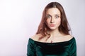 Portrait of surprised woman with freckles and classic green dress.