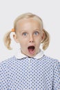 Portrait of a surprised young girl with mouth open over white background