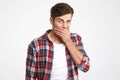 Portrait of a surprised young man covering mouth with hand Royalty Free Stock Photo