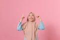 Portrait of a surprised young muslim woman pointing fingers up Royalty Free Stock Photo