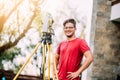 Portrait of survey engineer using and working with total station theodolite at landscaping project Royalty Free Stock Photo