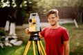 Surveyor caucasian engineer working with total station at landscaping project