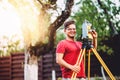 Surveyor engineer working with total station on garden elevation Royalty Free Stock Photo