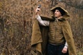 Portrait of survivalist male wearing tent raincoat searching for reception signal, making video call or recording video Royalty Free Stock Photo