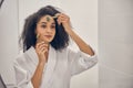 Woman with massage tools looking in the mirror