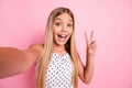 Portrait of sweet blond girl doing selfie show v-sign wear white cloth isolated on pastel pink color background Royalty Free Stock Photo