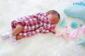 Portrait of sweet dreams newborn baby boy sleeping on white fur background with soft fabric mobile Royalty Free Stock Photo