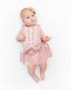 Portrait of a sweet infant wearing a pink dress, headband bow, isolated on white in studio. Royalty Free Stock Photo