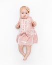 Portrait of a sweet infant wearing a pink dress, headband bow, isolated on white in studio. Royalty Free Stock Photo