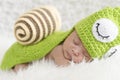 Portrait of sweet newborn baby in knitted snail costume